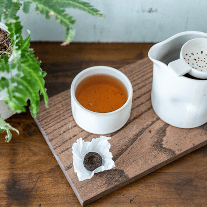 Shou Puerh Tou Cha tea on a wooden board in a white mug